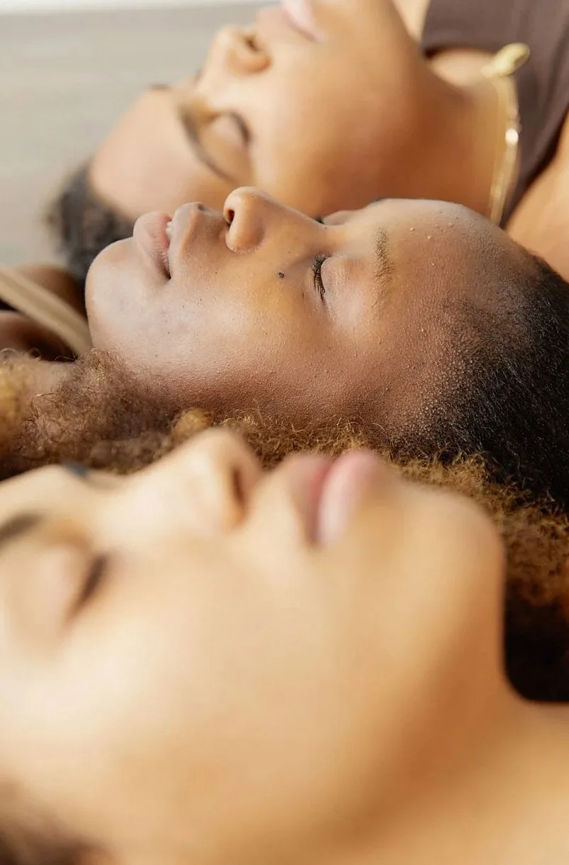 Three people resting side by side with their eyes closed
