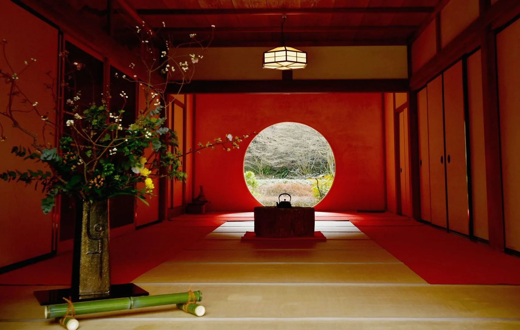 Tatami room with a round window and a flower arrangement