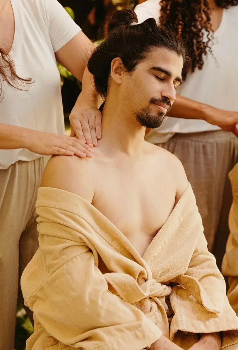 Man in a robe having his shoulders massaged